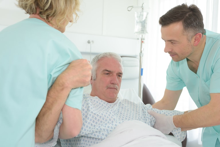 Bilde av eldre mann som får hjelp