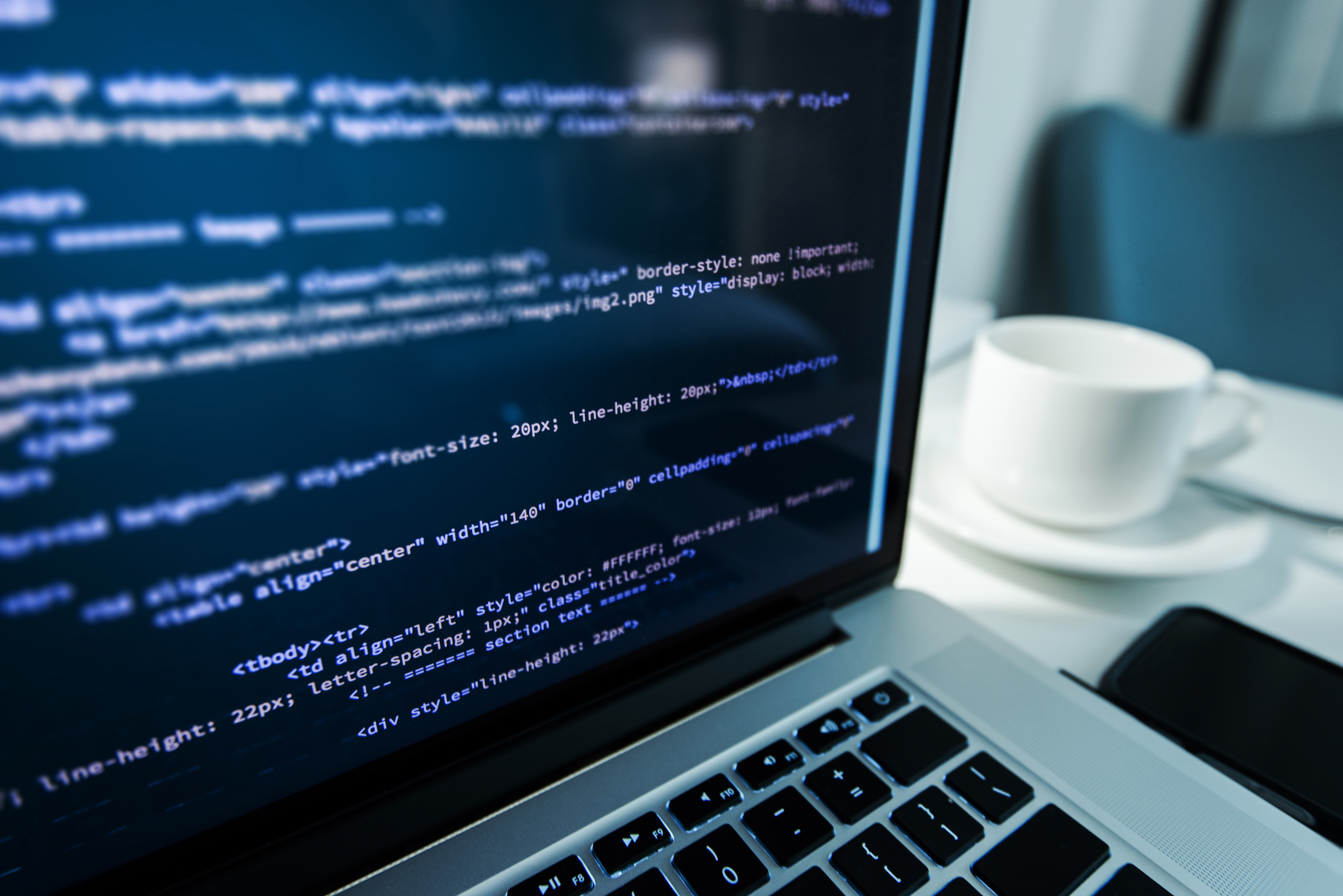 BIlde av en datamaskin. På dataskjermen er det ulike koder som er programmert.